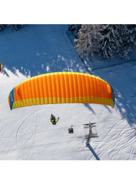 Vela de parapente Nova Nivo volando sobre montaña nevada