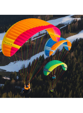 Grupo de pilotos volando con la vela de parapente Nova Prion 6 sobre montaña nevada